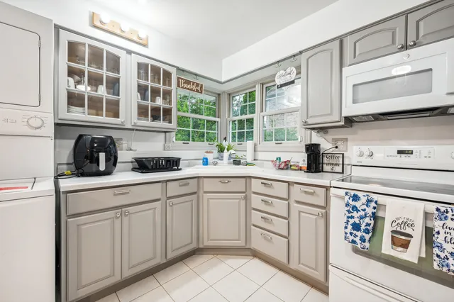 a kitchen with white cabinets a sink and a window
