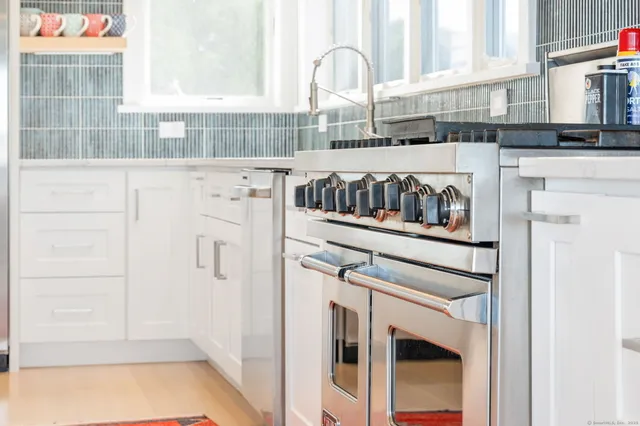 a kitchen with a white cabinets and a stove with a sink