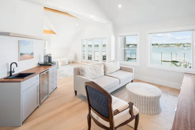 a large kitchen with stainless steel appliances a white table chairs and a large window
