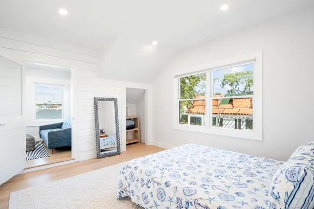 a bedroom with a bed and a window with chair