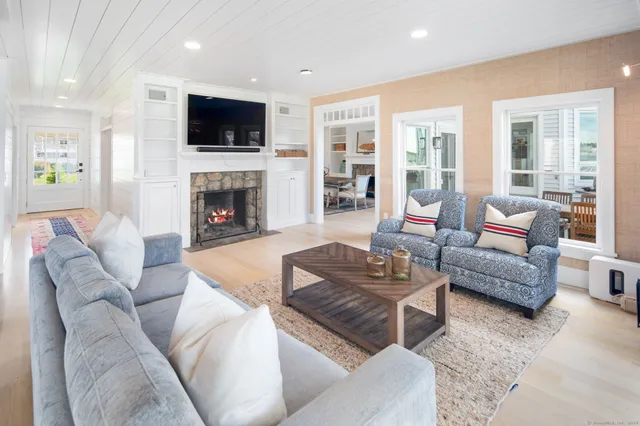 a living room with furniture a fireplace and a flat screen tv
