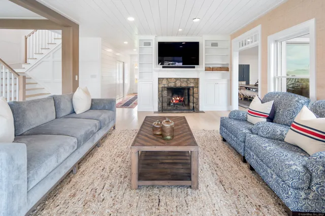 a living room with furniture a flat screen tv and a fireplace
