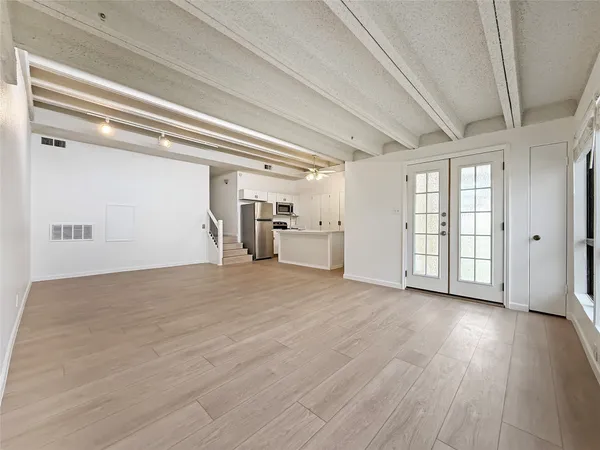 a view of empty room with wooden floor and window