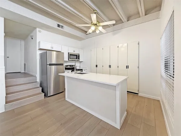 a kitchen with refrigerator and cabinets