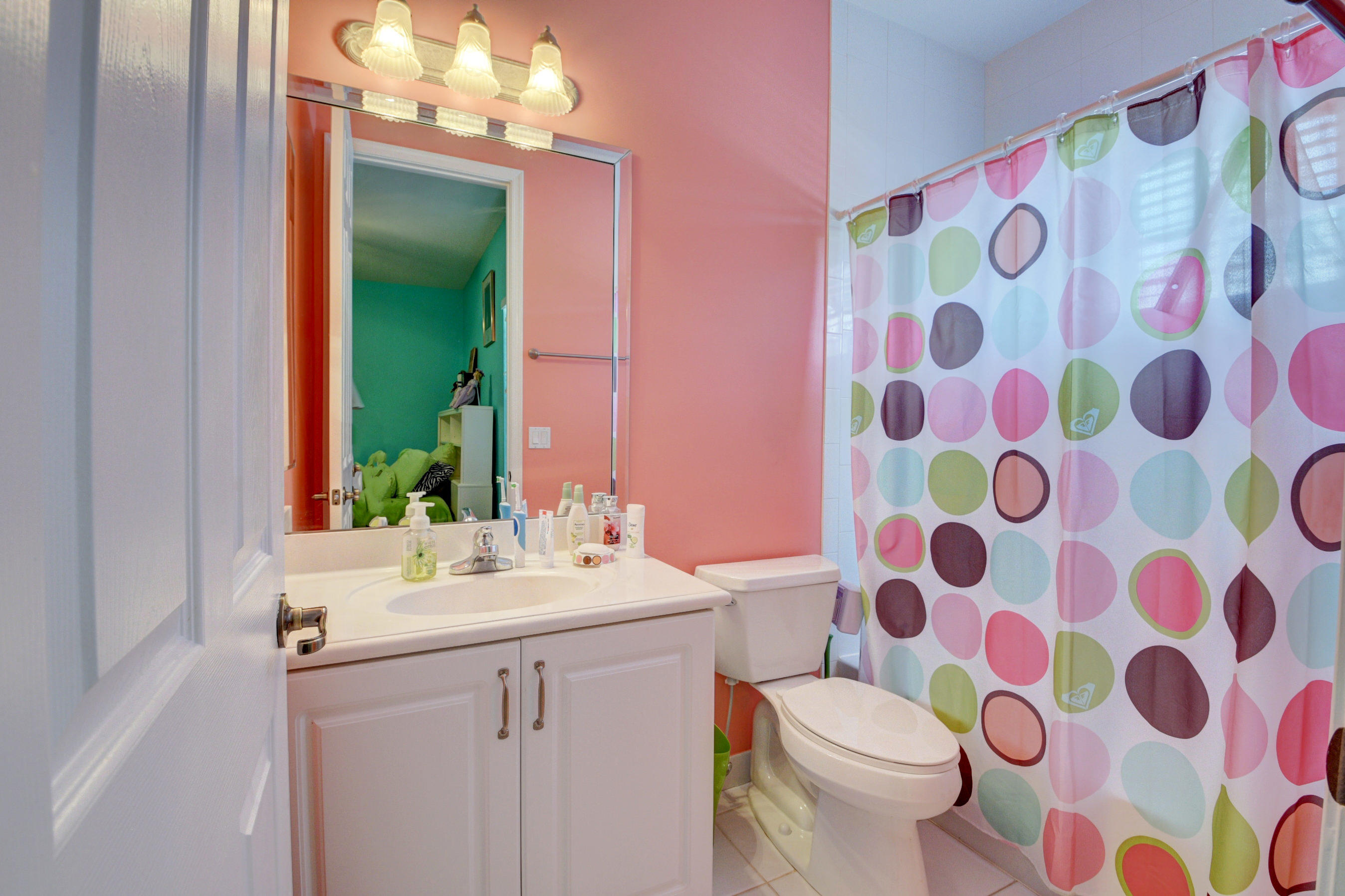 16155 Rosecroft Terrace Delray Beach, FL 33446 - Photo 24 of 40 a bathroom with a sink a toilet a mirror and shower curtain