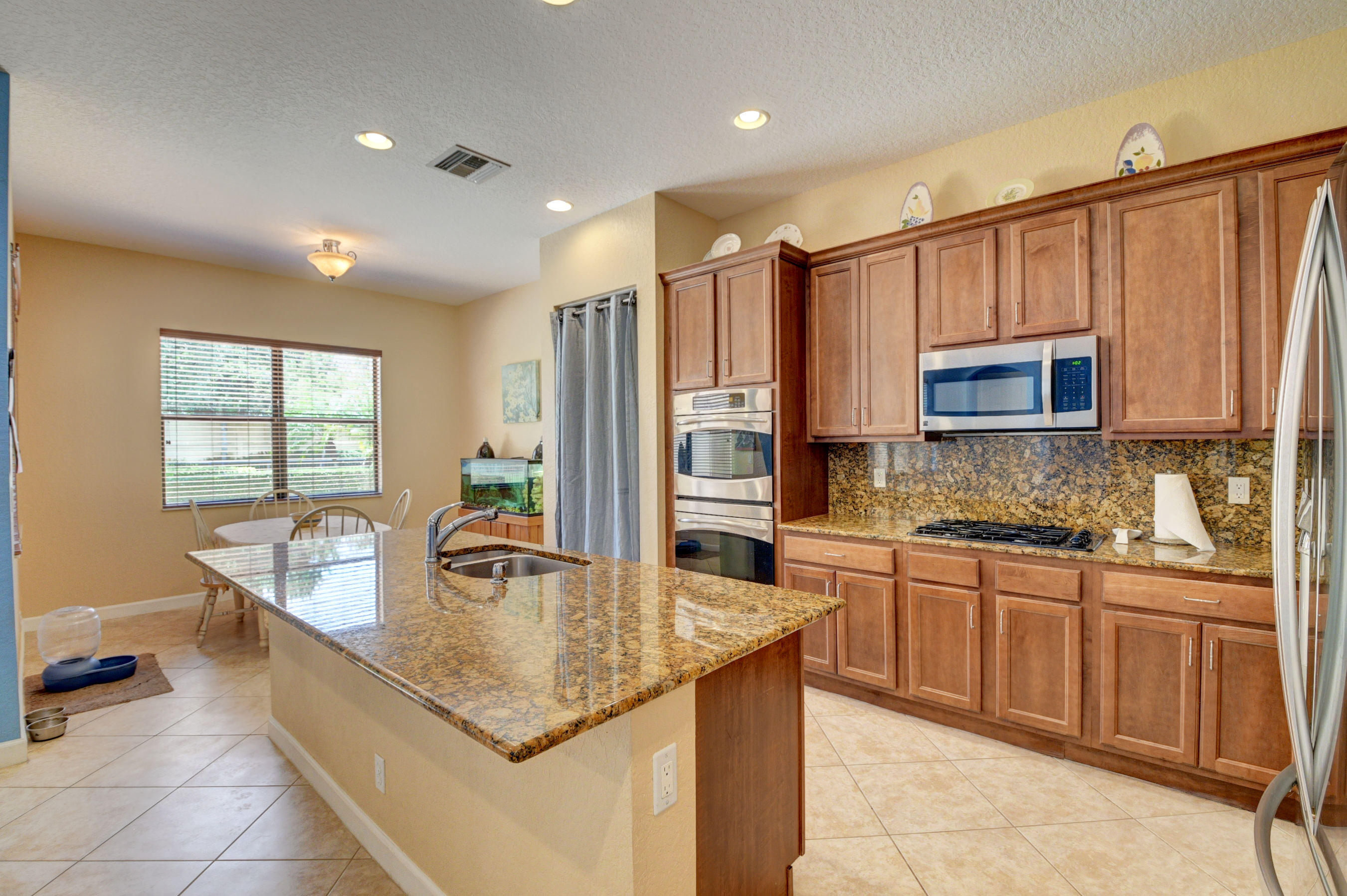 16155 Rosecroft Terrace Delray Beach, FL 33446 - Photo 3 of 40 a kitchen with stainless steel appliances granite countertop a sink refrigerator and cabinets