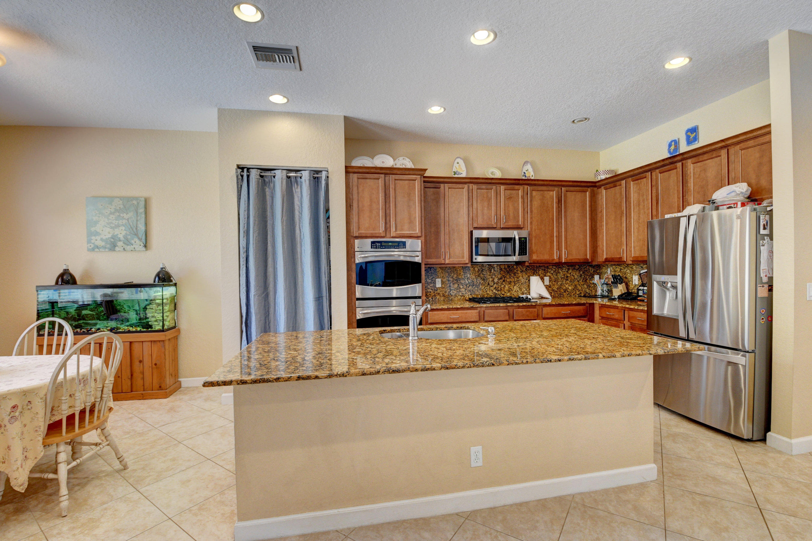 16155 Rosecroft Terrace Delray Beach, FL 33446 - Photo 5 of 40 a kitchen with stainless steel appliances granite countertop a refrigerator and a stove top oven