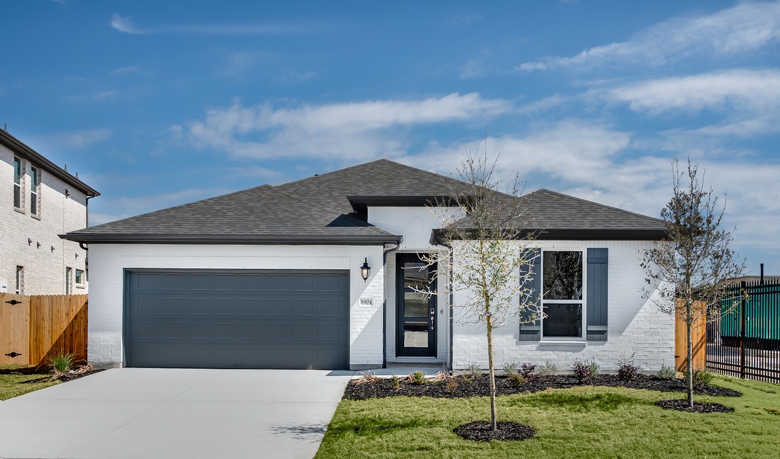 6904 Quiet Strm Way Buda, TX 78610 - Photo 1 of 1 a front view of a house with garden