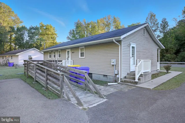 a view of house with outdoor space and trees in the background