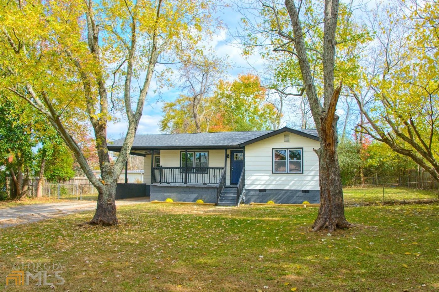 a front view of a house with a garden and tree