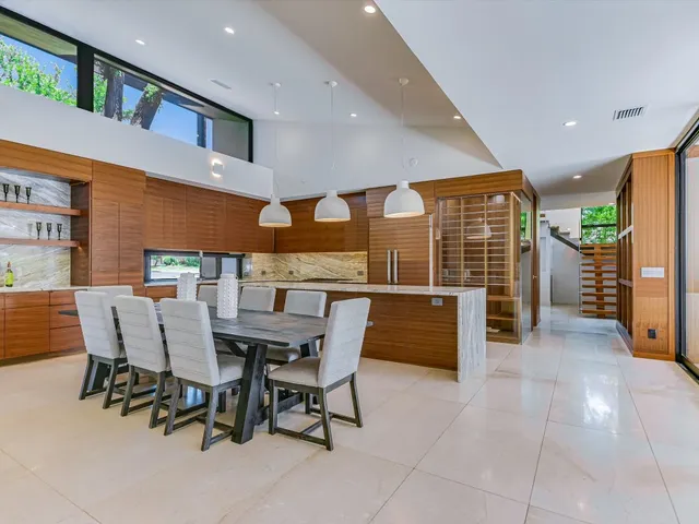a dining room with furniture and a floor to ceiling window