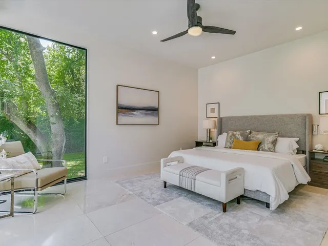 a bedroom with a bed a chair and a chandelier