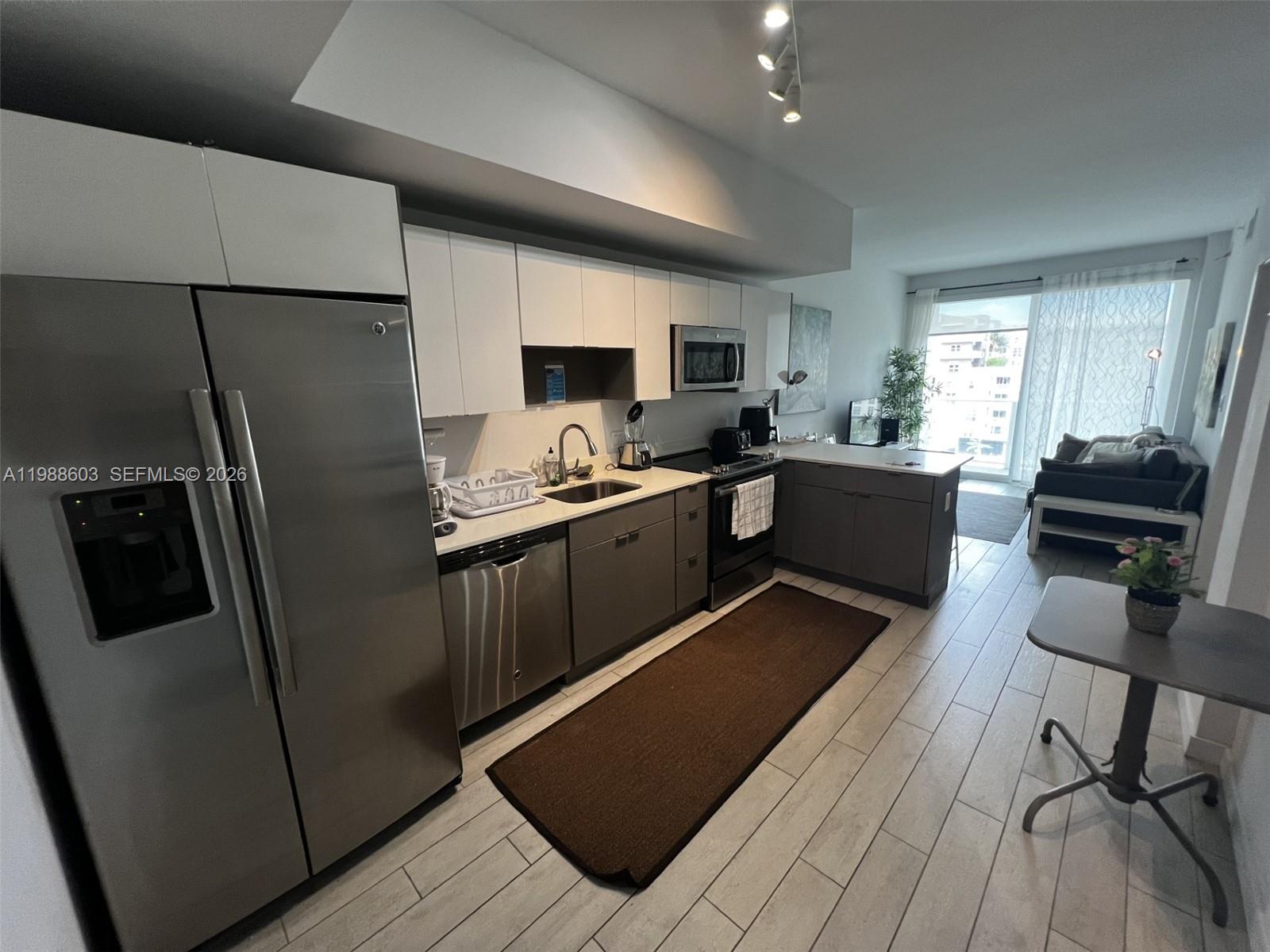 a kitchen with stainless steel appliances a refrigerator and a stove top oven