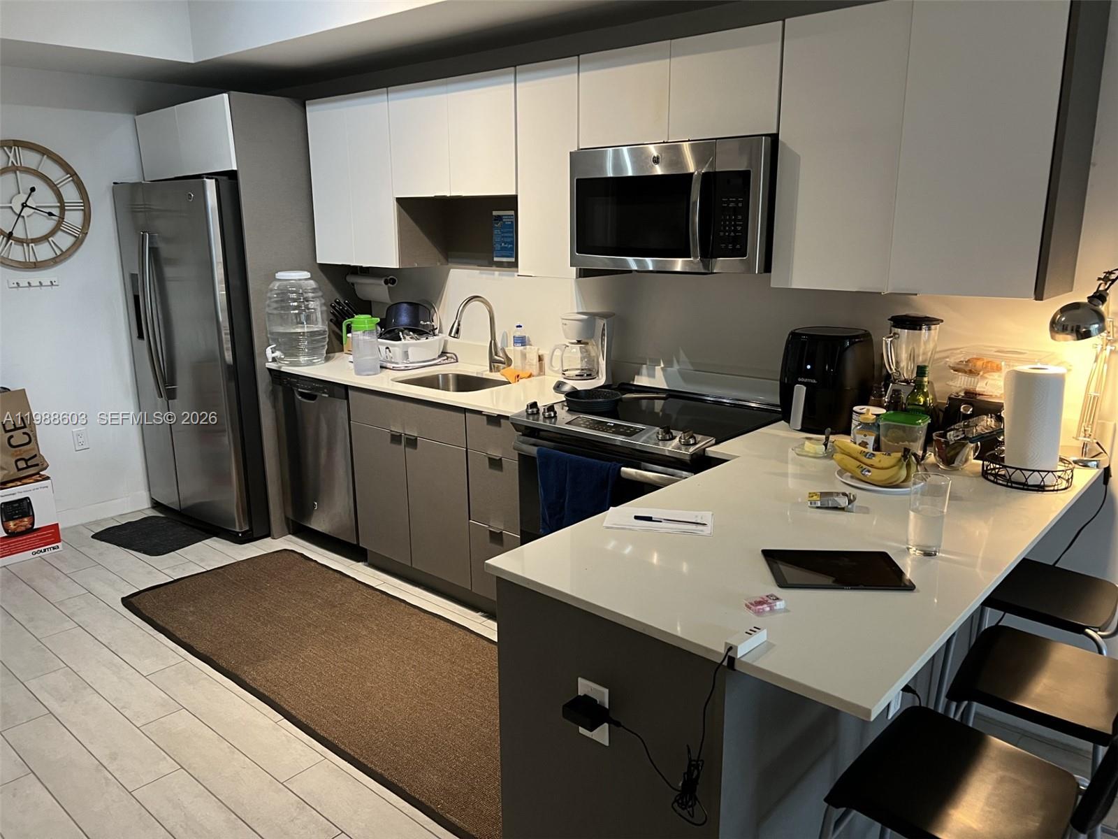 321 Northeast 26th Street, Unit 704 Miami, FL 33137 - Photo 3 of 9 a kitchen with a sink a stove and refrigerator