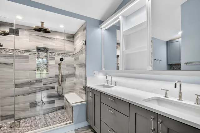 a bathroom with a double vanity sink toilet and shower