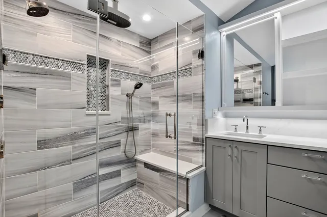 a bathroom with a shower sink and mirror