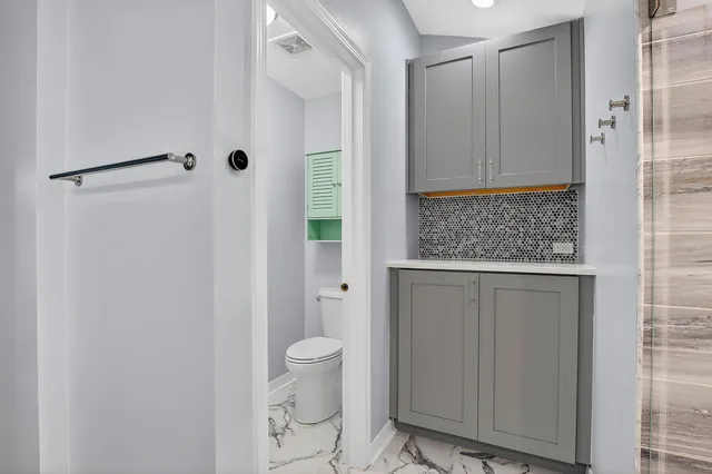 a bathroom with a granite countertop shower and a sink