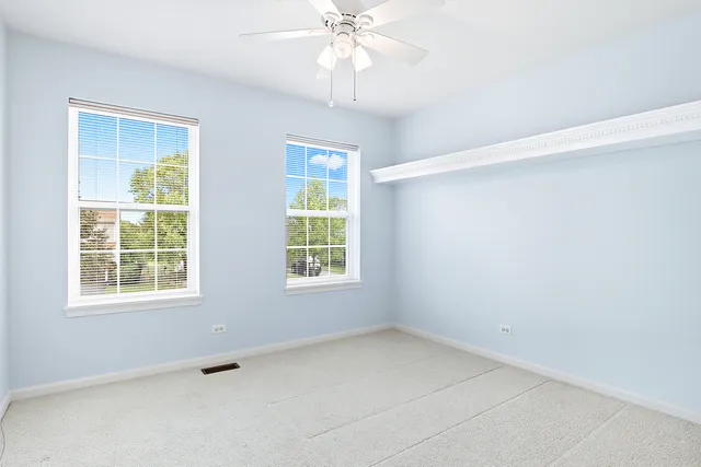 an empty room with a window and a fan