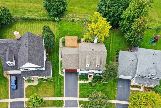 an aerial view of a house with a garden and lake view