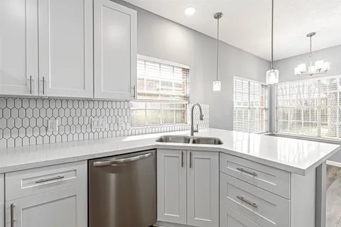 a kitchen with stainless steel appliances granite countertop a sink a window and cabinets