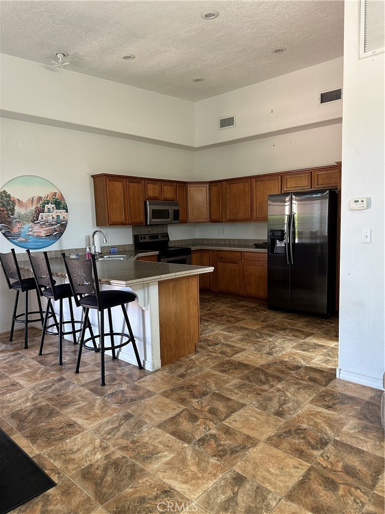 1100 Beach Drive Needles, CA 92363 - Photo 3 of 13 a kitchen with stainless steel appliances granite countertop a stove a sink a dining table and chairs