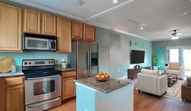 a kitchen with stainless steel appliances kitchen island granite countertop a stove a sink dishwasher a microwave oven with granite countertops and cabinets