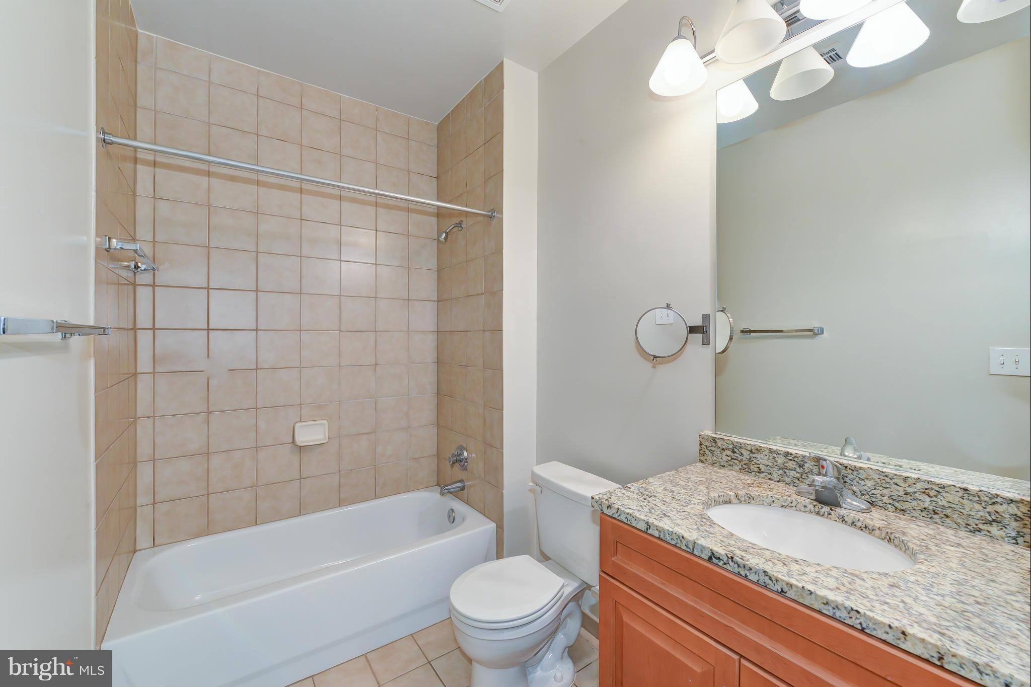 1111 25th Street Northwest, Unit 905 Washington, DC 20037 - Photo 14 of 25 a bathroom with a granite countertop sink a toilet and bathtub