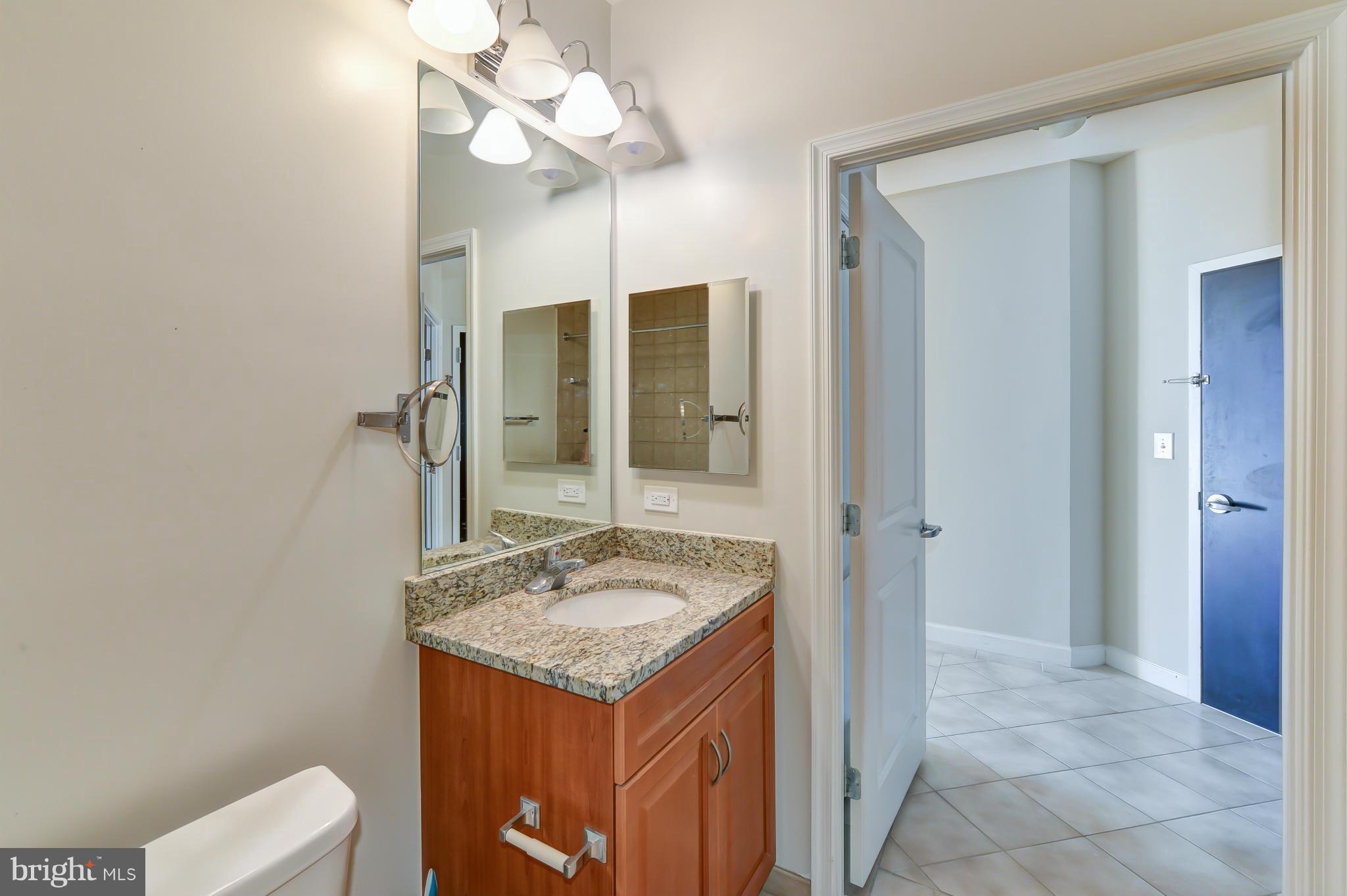 1111 25th Street Northwest, Unit 905 Washington, DC 20037 - Photo 16 of 25 a bathroom with a sink a light fixture and a mirror