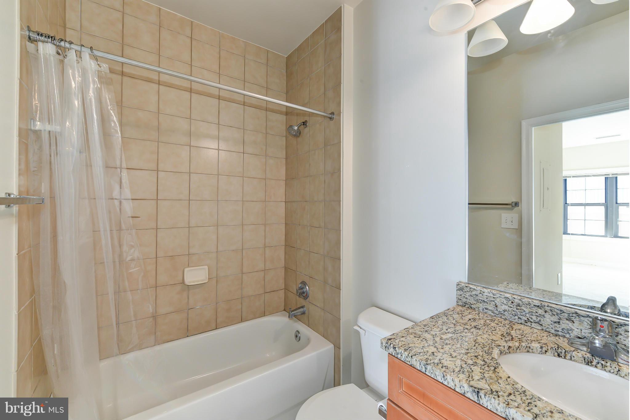 1111 25th Street Northwest, Unit 905 Washington, DC 20037 - Photo 17 of 25 a bathroom with a granite countertop sink and a mirror