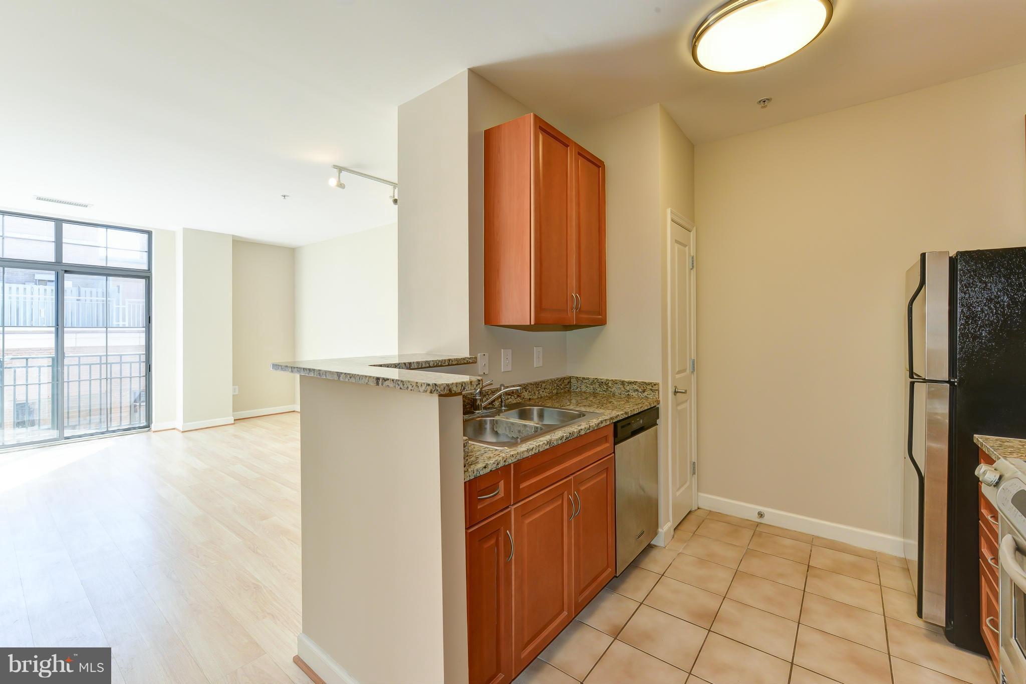 1111 25th Street Northwest, Unit 905 Washington, DC 20037 - Photo 7 of 25 a kitchen with stainless steel appliances granite countertop a refrigerator and a stove