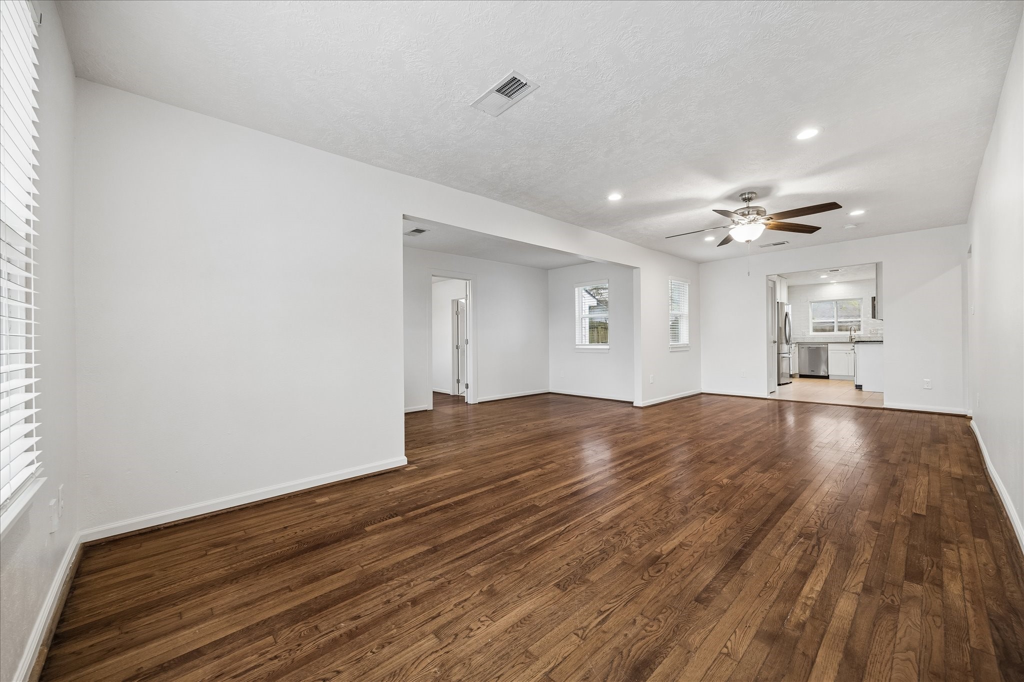 7515 Magnolia Street Houston, TX 77023 - Photo 3 of 16 The spacious 26×11 living area features beautiful original hardwood floors, recessed lighting, and a ceiling fan with light. Its functional, open layout flows seamlessly, creating an inviting space for everyday living and entertaining.
