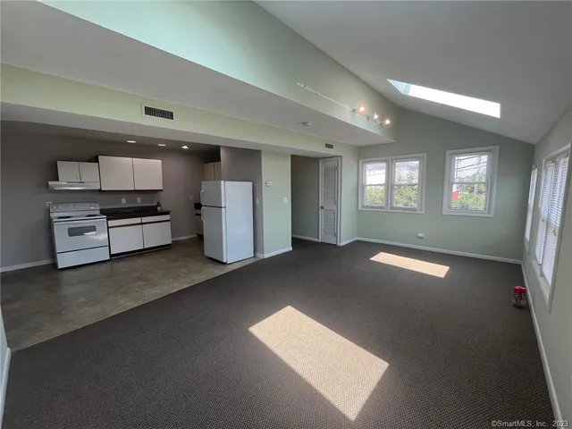 a view of a kitchen with refrigerator and windows
