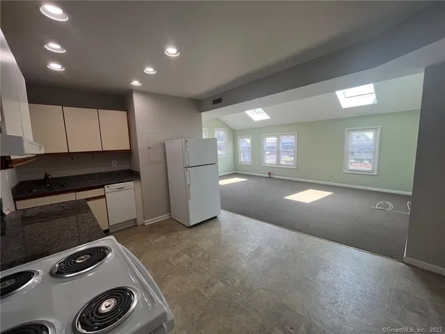 a kitchen with granite countertop white cabinets and white appliances