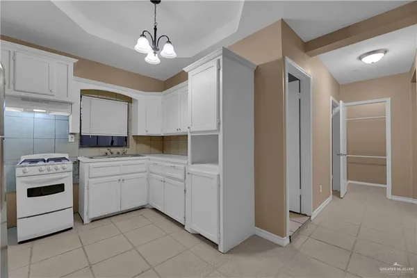a kitchen with white cabinets and white appliances