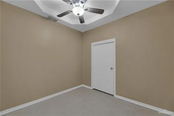 an empty room with a window and a fan
