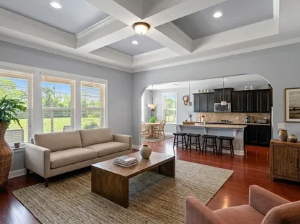 a kitchen with stainless steel appliances kitchen island granite countertop a refrigerator a stove top oven a sink dishwasher and wooden cabinets with wooden floor