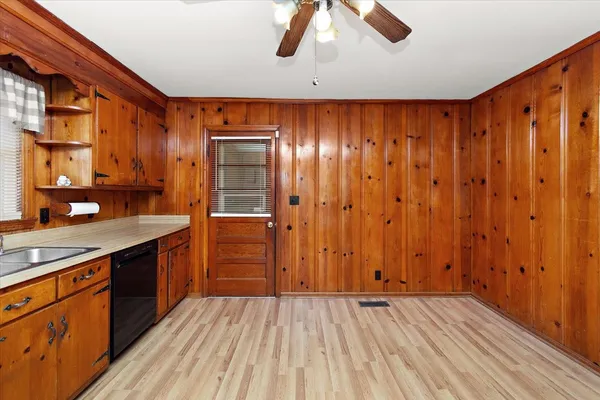 a view of a kitchen with a sink and wooden cabinets