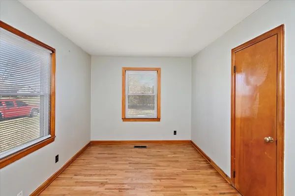 a view of a room with wooden floor and windows