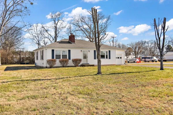 a white house with a large tree in front of it