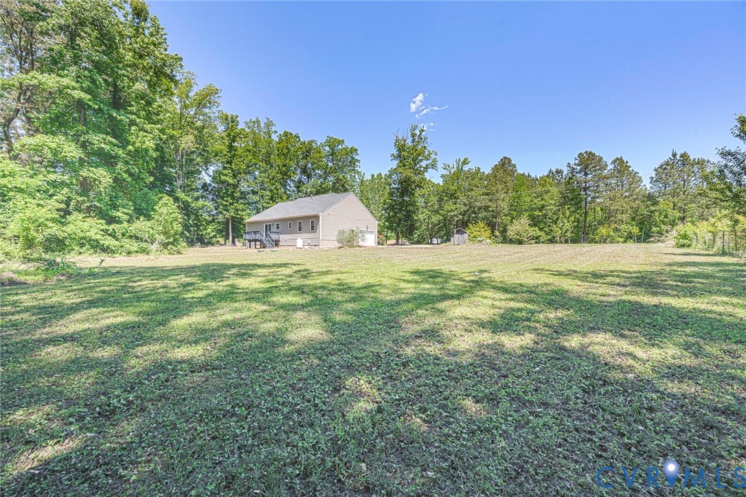1297 Manfield Road Aylett, VA 23009 - Photo 6 of 41 a view of a big yard with a house in the background