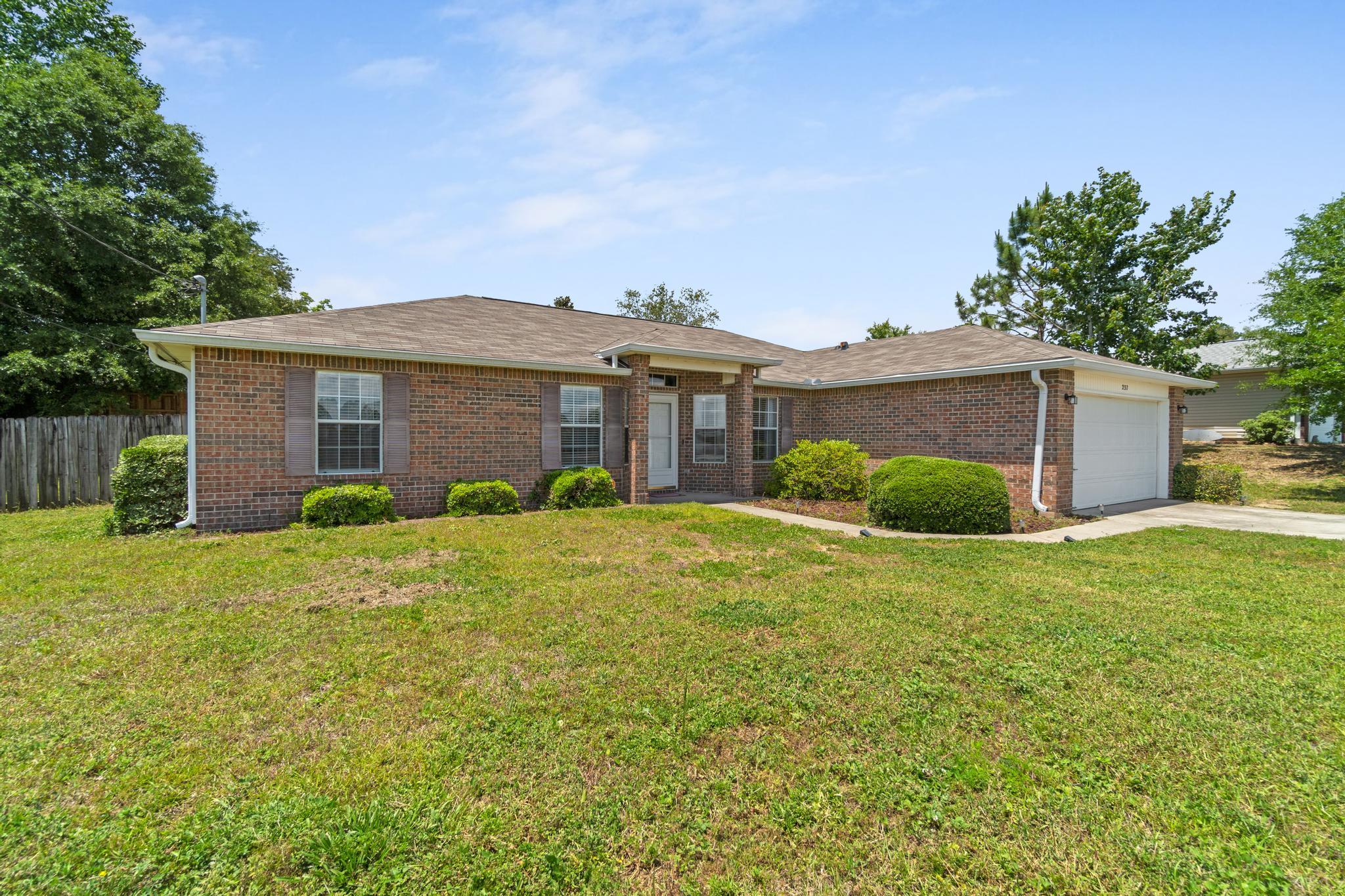 a front view of house with yard and trees