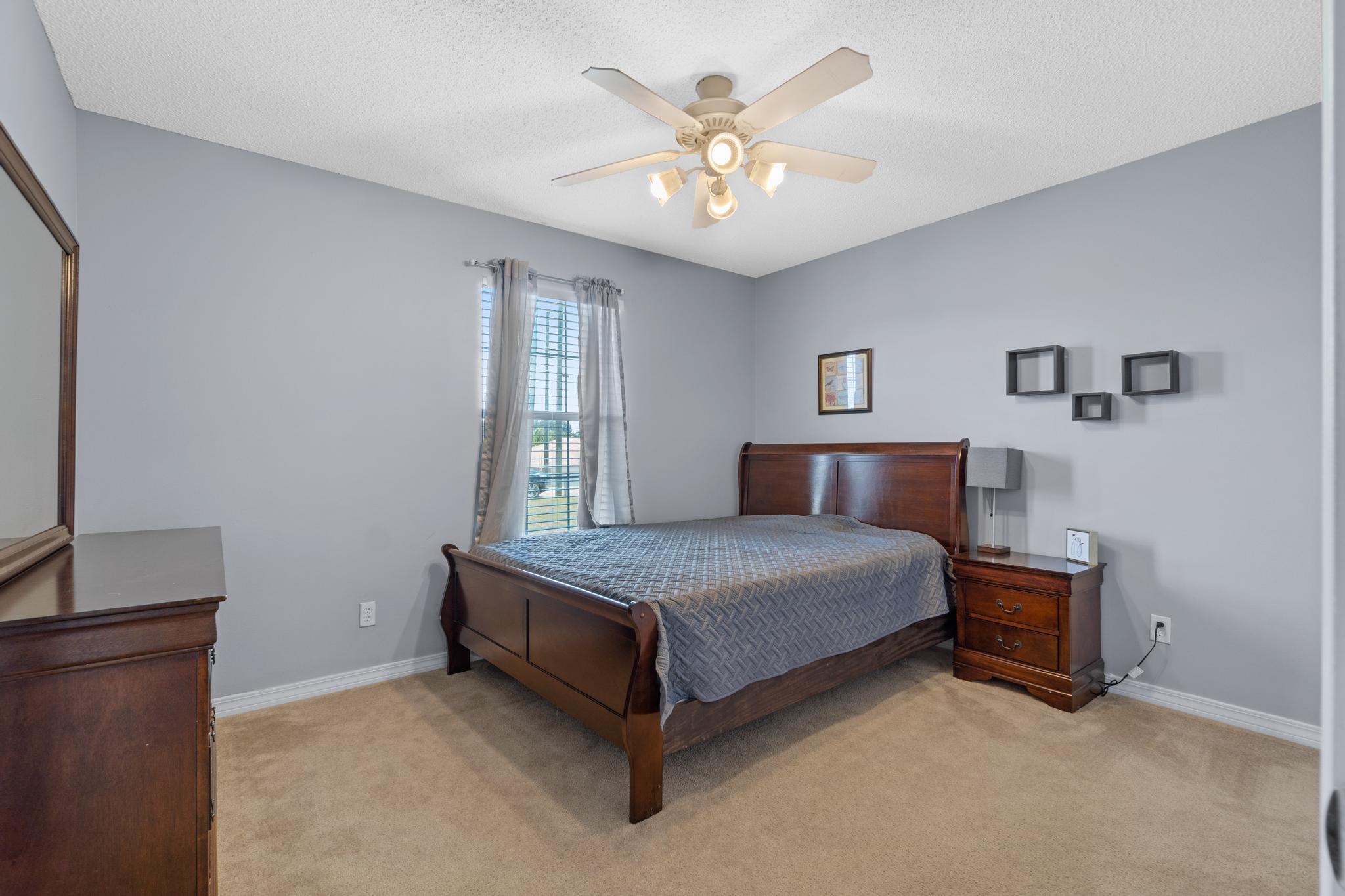 237 Trish Drive Crestview, FL 32536 - Photo 27 of 41 a spacious bedroom with a bed and a chandelier
