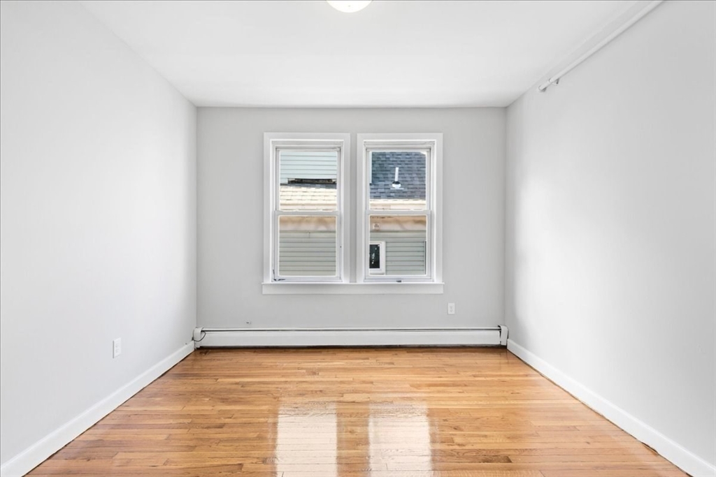 75 Bellevue Street, Unit 2L Boston, MA 02125 - Photo 5 of 10 a view of an empty room with wooden floor and a window