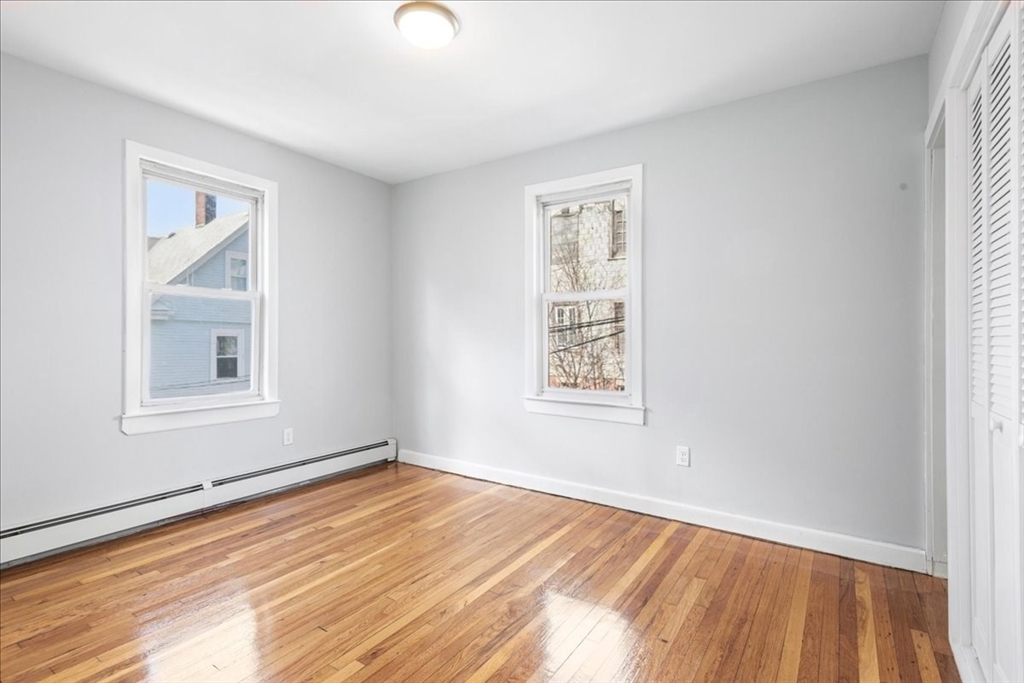 75 Bellevue Street, Unit 2L Boston, MA 02125 - Photo 7 of 10 a view of an empty room with wooden floor and a window