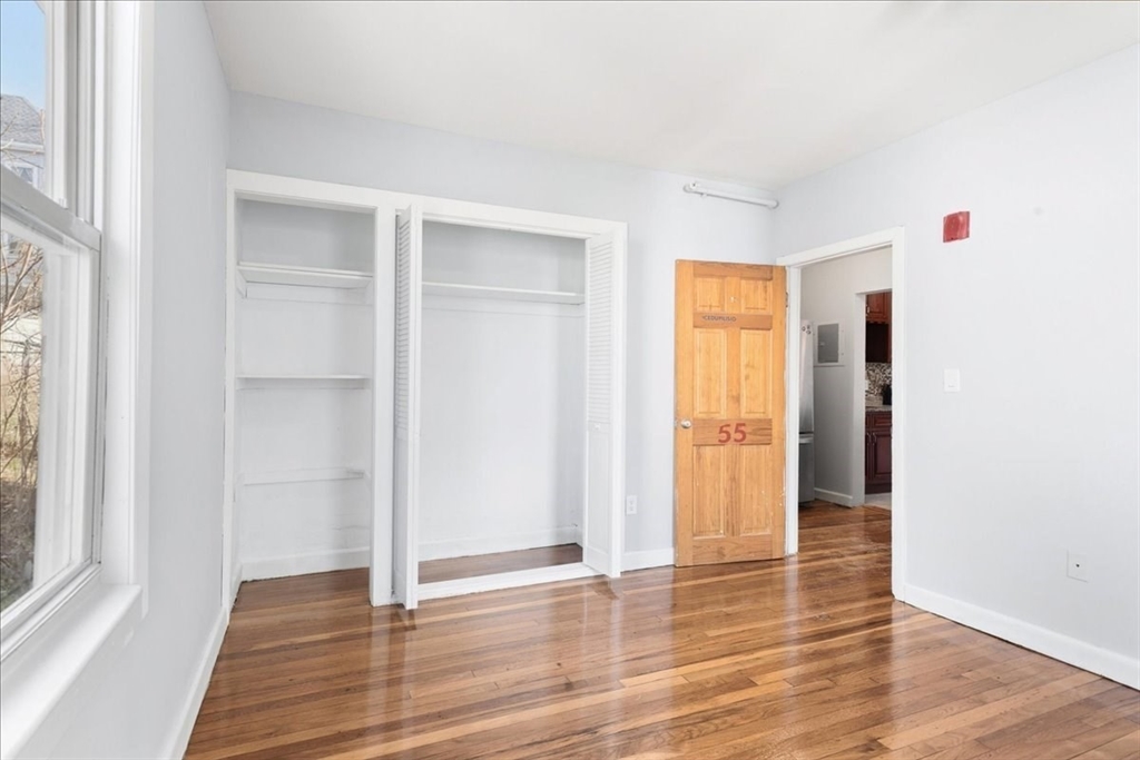75 Bellevue Street, Unit 2L Boston, MA 02125 - Photo 8 of 10 a view of an empty room with wooden floor and a window