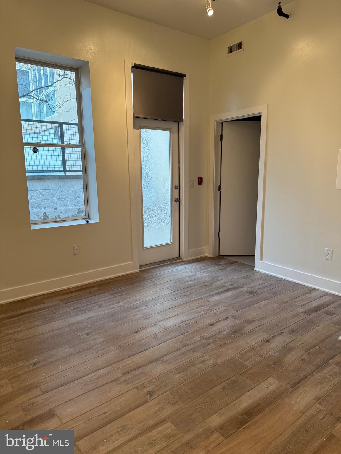 4334 Farragut Street, Unit H Hyattsville, MD 20781 - Photo 7 of 9 an empty room with wooden floor and windows