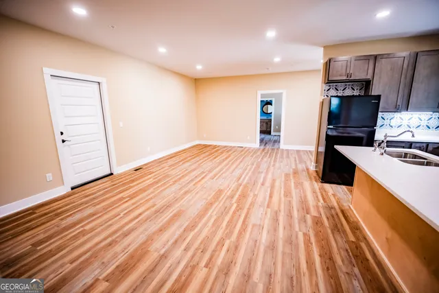 a view of empty room with wooden floor and windows