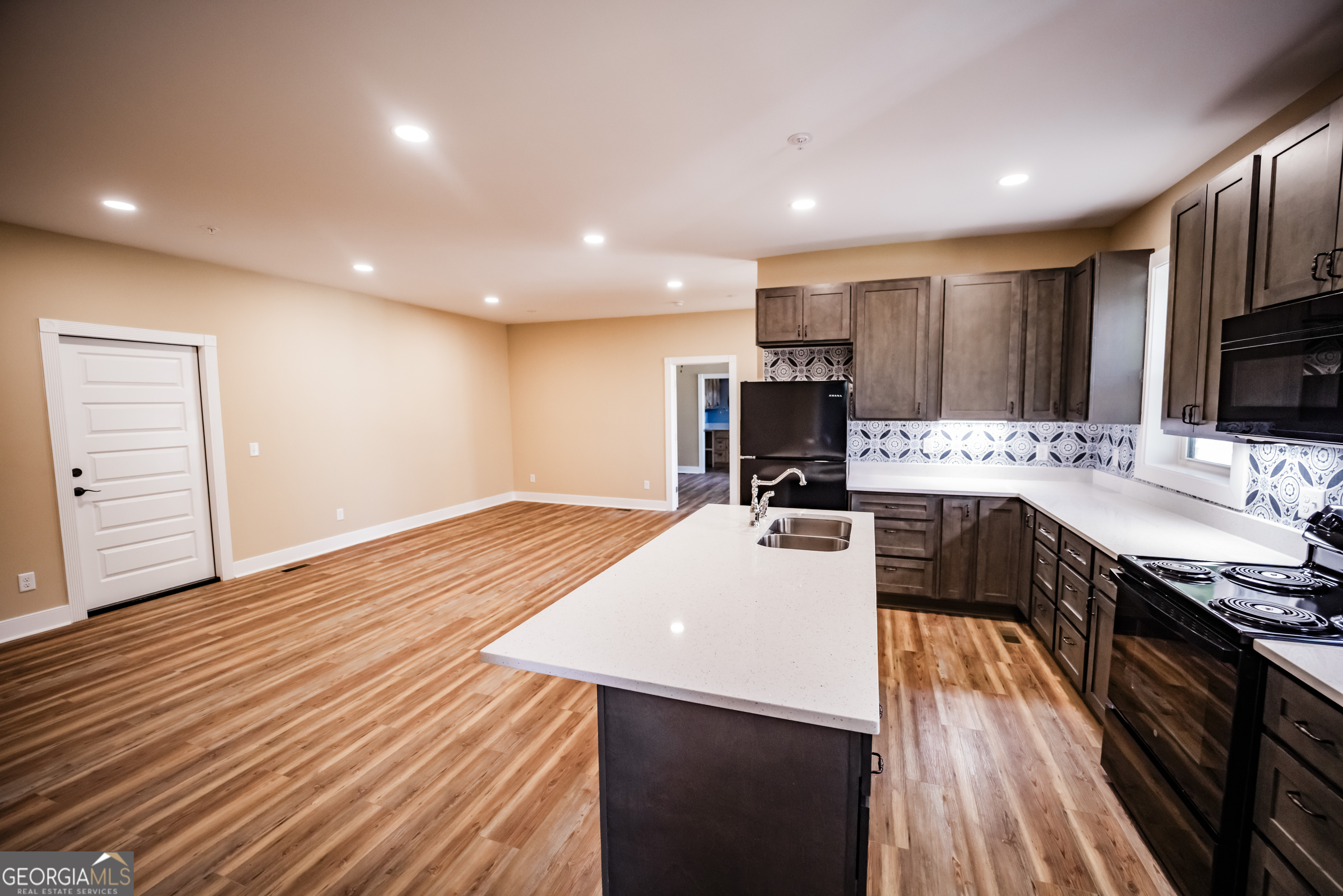 210 West 8th Street, Unit 1 Tifton, GA 31794 - Photo 6 of 23 a large kitchen with stainless steel appliances a large counter top a stove and a wooden floors