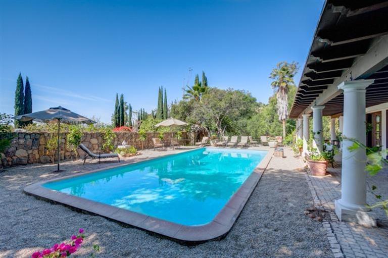 1329 Foothill Road Ojai, CA 93023 - Photo 8 of 24 a view of a swimming pool with a bench and some trees in the background