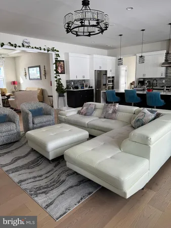 a living room with furniture kitchen and a chandelier